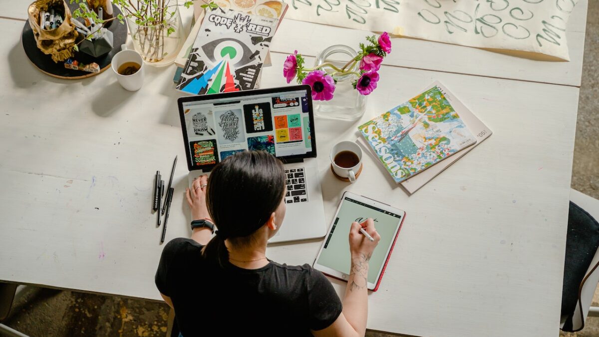 kobieta siedząca przy komputerze szukająca inspiracji i projektująca grafiki