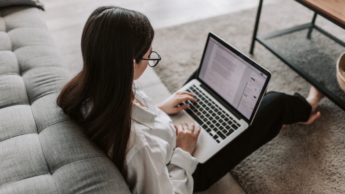 kobieta siedząca na podłodze z laptopem wykonująca przelew na mikrorachunek podatkowy